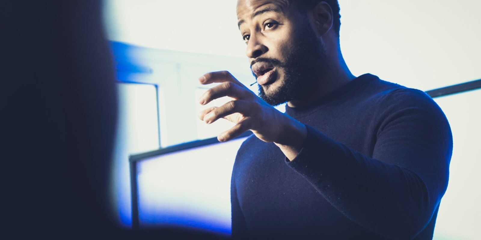 A man standing in front of a projection screen