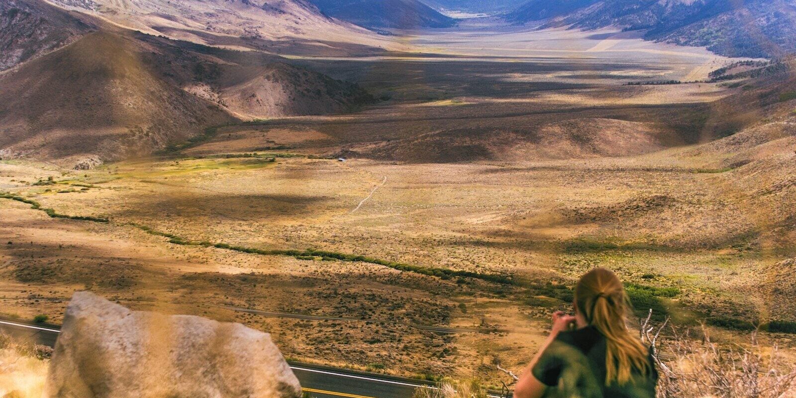 woman sitting near mountains